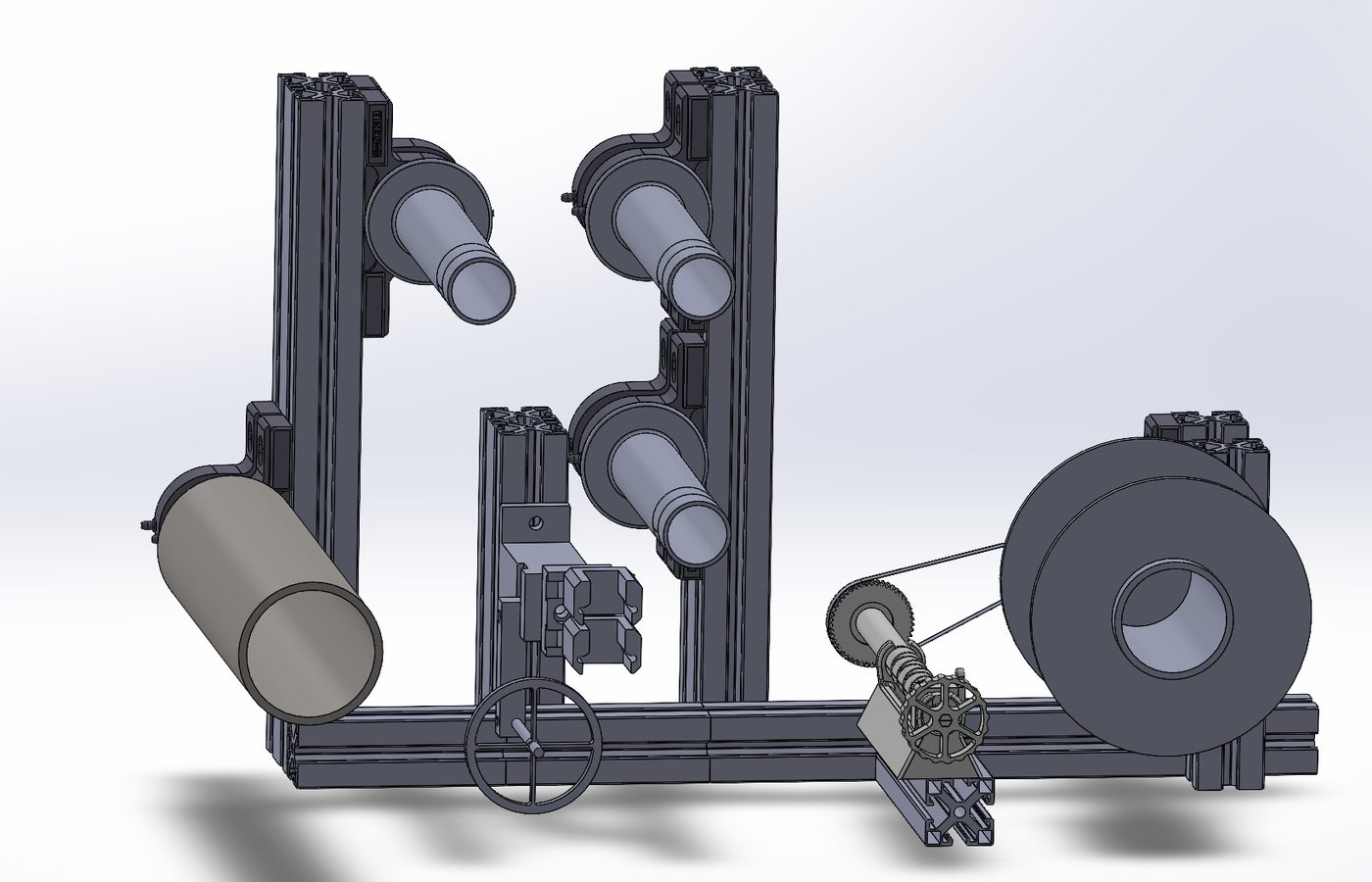 CAD assembly of the towpreg machine — spool holder, guide rollers, dip wheel and take-up spool on an aluminium profile frame